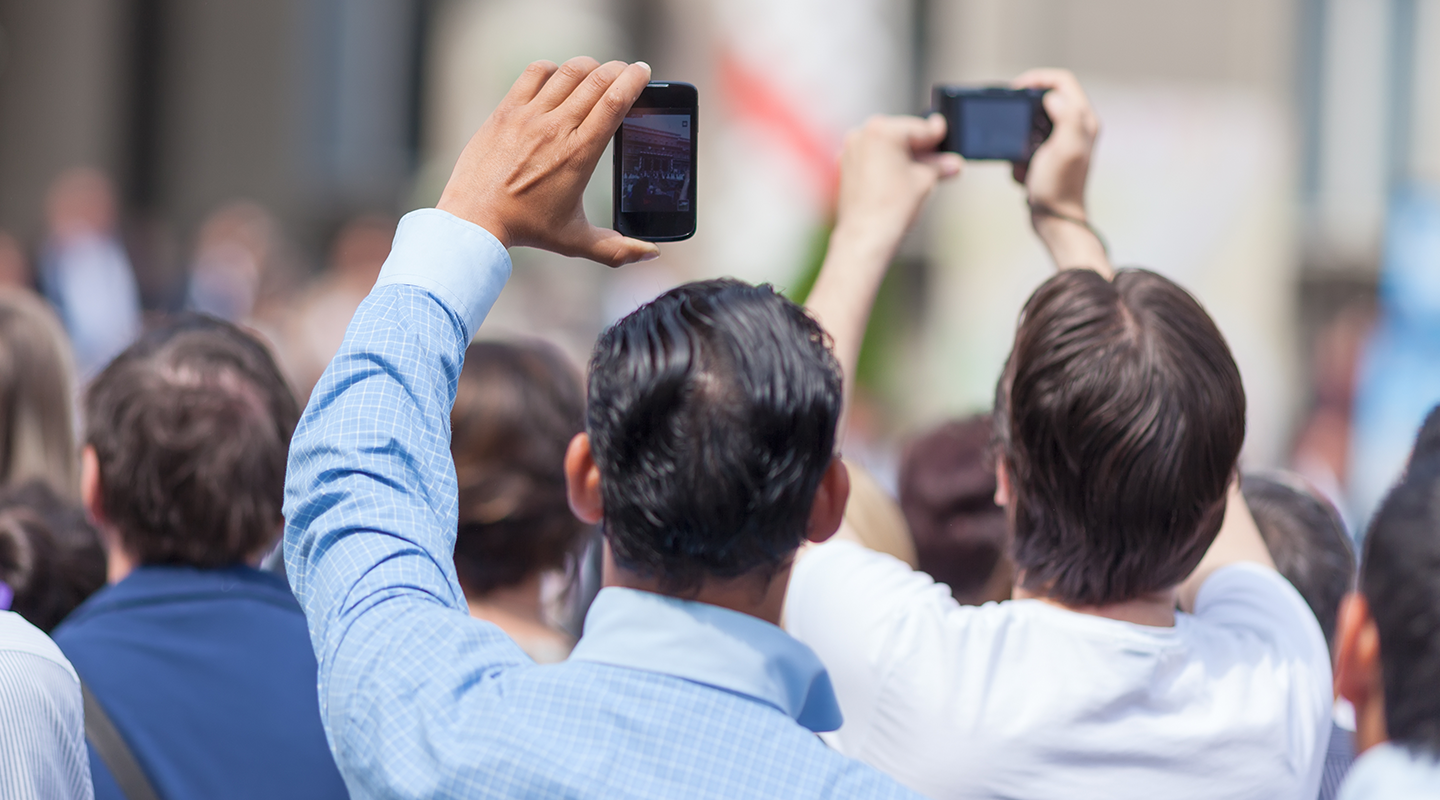 Bystanders taking photos on mobile phones
