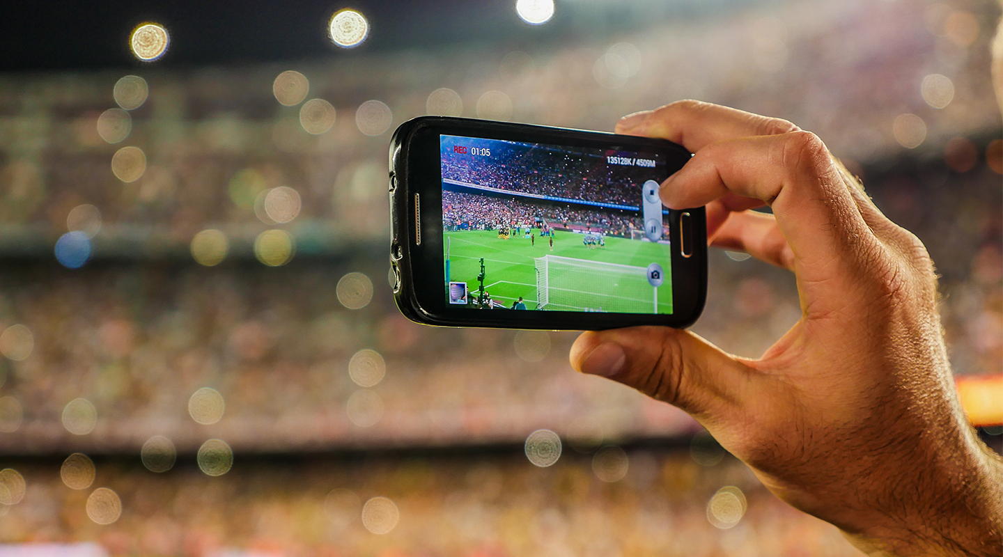 Soccer fan capturing a photo of the field to publish in real-time.